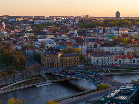 Aerial view of the historic cityscape with red rooftops the Neris river and Mindaugas Bridge during golden hour in Vilnius County Lithuania. Aerial view of the historic cityscape with red rooftops the Neris river and Mindaugas Bridge during golden hour in Vilnius County Lithuania.