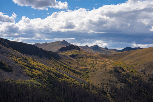 View of the rugged landscape surrounding San Luis Peak with rocky slopes and alpine vegetation under a dramatic cloudy sky in Creede Colorado United States. View of the rugged landscape surrounding San Luis Peak with rocky slopes and alpine vegetation under a dramatic cloudy sky in Creede Colorado United States.