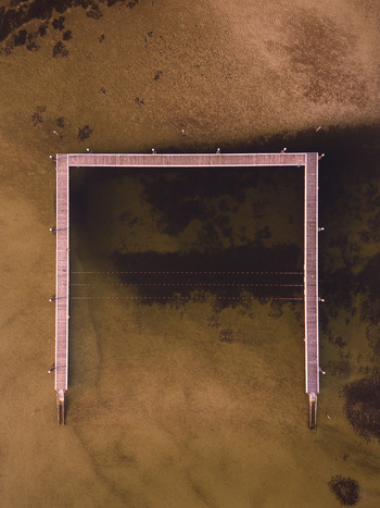 Aerial view of the U shaped wooden jetty extending into the shallow sandy waters of Emu Point Western Australia Australia. Aerial view of the U shaped wooden jetty extending into the shallow sandy waters of Emu Point Western Australia Australia.