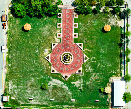 Aerial view of the landscaped courtyard at Ghazi University with a geometric red brick pattern and central fountain surrounded by green lawns in Dera Ghazi Khan Punjab Pakistan.