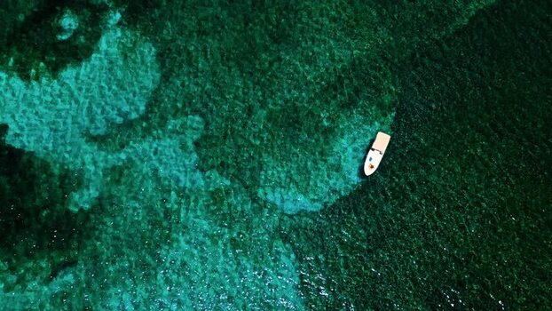 Aerial view of a boat on turquoise water in Guanaja Honduras. Aerial view of a boat on turquoise water in Guanaja Honduras.