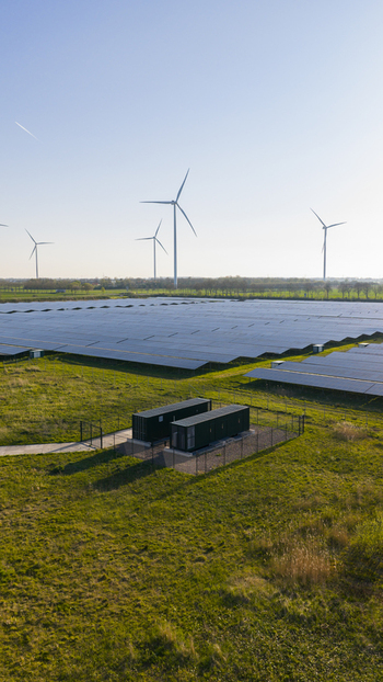 Aerial view of Solar park Delfzijl featuring rows of solar panels and wind turbines under a clear sky in Farmsum Groningen Netherlands. Aerial view of Solar park Delfzijl featuring rows of solar panels and wind turbines under a clear sky in Farmsum Groningen Netherlands.