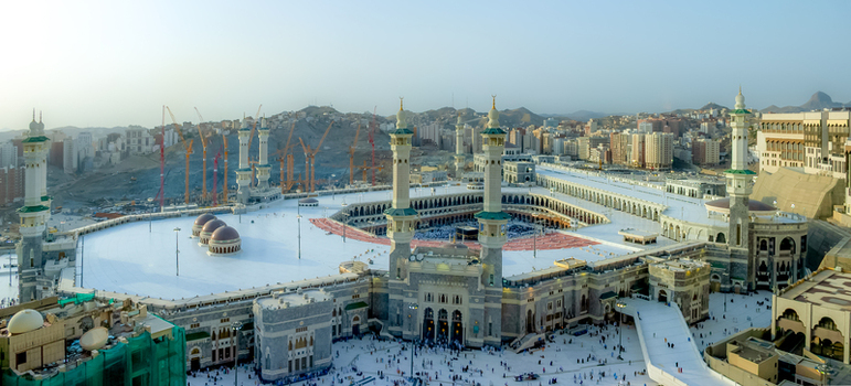 Aerial view of Masjid al Haram with its towering minarets expansive white marble courtyards and surrounding urban development with cranes Makkah Makkah Province Saudi Arabia. Aerial view of Masjid al Haram with its towering minarets expansive white marble courtyards and surrounding urban development with cranes Makkah Makkah Province Saudi Arabia.