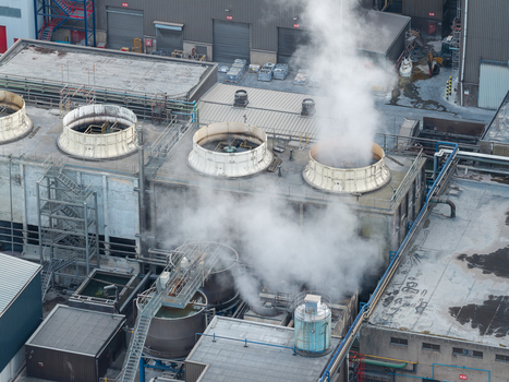 Aerial view of the industrial facilities at Haven Genk with large cooling towers emitting steam over the steel production plant in Genk Vlaanderen Belgium.