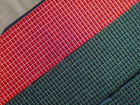 Aerial view of red and green plastic crates arranged in a grid pattern in Poland. Aerial view of red and green plastic crates arranged in a grid pattern in Poland.