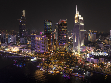Aerial view of the illuminated skyline at night featuring the Bitexco Financial Tower and skyscrapers along the Saigon River Ho Chi Minh City Ho Chi Minh Vietnam. Aerial view of the illuminated skyline at night featuring the Bitexco Financial Tower and skyscrapers along the Saigon River Ho Chi Minh City Ho Chi Minh Vietnam.