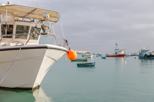 View of calm turquoise water reflects the hulls of colorful fishing boats bobbing gently in the harbor a vibrant scene Marsaxlokk Malta. View of calm turquoise water reflects the hulls of colorful fishing boats bobbing gently in the harbor a vibrant scene Marsaxlokk Malta.