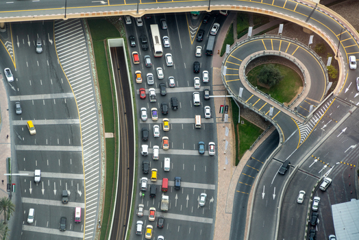 View of heavy traffic flow on a multi lane highway with cars and buses near a circular overpass ramp in Dubai Dubai United Arab Emirates. View of heavy traffic flow on a multi lane highway with cars and buses near a circular overpass ramp in Dubai Dubai United Arab Emirates.