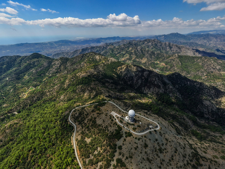 Aerial view of the Kionia radar station situated on a mountain peak with a winding road surrounded by lush greenery and rocky terrain in Lazanias Lefkosia Cyprus. Aerial view of the Kionia radar station situated on a mountain peak with a winding road surrounded by lush greenery and rocky terrain in Lazanias Lefkosia Cyprus.