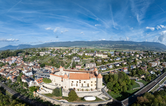 Aerial view of Chateau de Grandson surrounded by historic buildings and lush greenery in Grandson Vaud Switzerland.