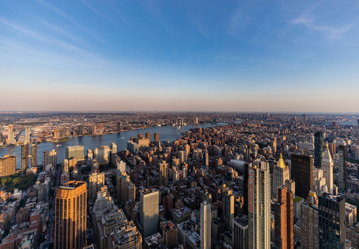 View of the Manhattan skyline with dense skyscrapers urban architecture and the East River under a clear blue sky in New York New York United States. View of the Manhattan skyline with dense skyscrapers urban architecture and the East River under a clear blue sky in New York New York United States.