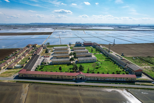 Aerial view of Azienda Agricola Veneria farm complex surrounded by flooded rice fields and green lawns under a bright sky Veneria Piemonte Italy. Aerial view of Azienda Agricola Veneria farm complex surrounded by flooded rice fields and green lawns under a bright sky Veneria Piemonte Italy.
