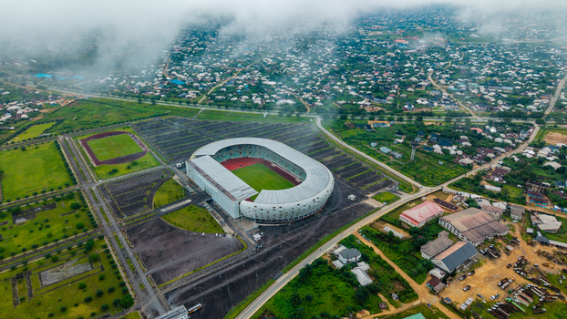 Aerial view of Godswill Akpabio Stadium surrounded by parking lots and urban sprawl under a cloudy sky in Uyo Akwa Ibom Nigeria. Aerial view of Godswill Akpabio Stadium surrounded by parking lots and urban sprawl under a cloudy sky in Uyo Akwa Ibom Nigeria.