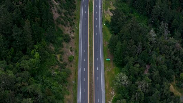 Aerial view of a highway through a dense forest United States. Aerial view of a highway through a dense forest United States.