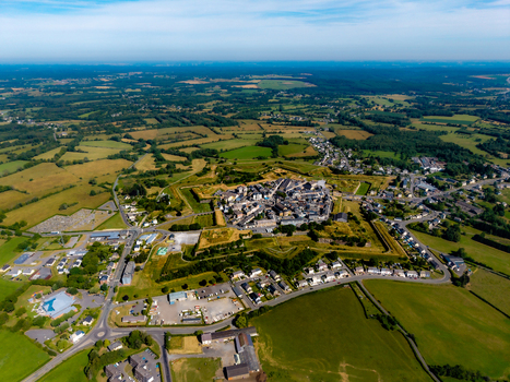 Aerial view of the star shaped historic fortifications of Fort Neuf surrounded by green fields and rural landscape in Rocroi Grand Est France. Aerial view of the star shaped historic fortifications of Fort Neuf surrounded by green fields and rural landscape in Rocroi Grand Est France.