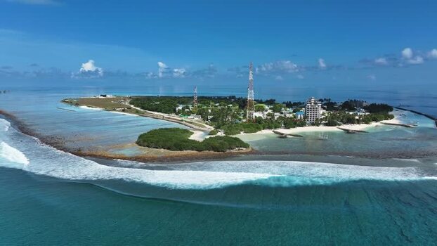 Aerial view of Thulusdhoo island with turquoise water Maldives.