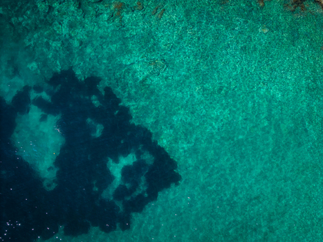 Aerial view of the crystal clear turquoise water and dark rocky seabed at Aquarium Beach in Jala Vlore County Albania. Aerial view of the crystal clear turquoise water and dark rocky seabed at Aquarium Beach in Jala Vlore County Albania.