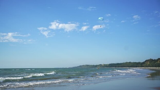 View of a person parasailing over the beach in Bangladesh.