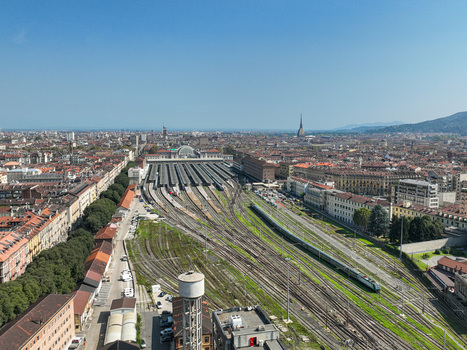 Aerial view of Porta Nuova railway station with numerous train tracks platforms and the urban skyline under a clear blue sky in Turin Piedmont Italy. Aerial view of Porta Nuova railway station with numerous train tracks platforms and the urban skyline under a clear blue sky in Turin Piedmont Italy.