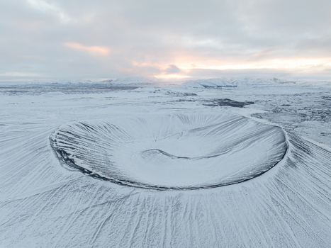 Aerial view of Hverfjall volcanic crater covered in snow under a dramatic winter sky in Thingeyjarsveit Iceland. Aerial view of Hverfjall volcanic crater covered in snow under a dramatic winter sky in Thingeyjarsveit Iceland.