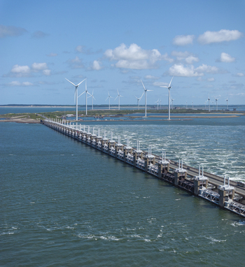 Aerial view of the Eastern Scheldt Storm Surge Barrier with wind turbines in the background surrounded by the North Sea in Vrouwenpolder Zeeland Netherlands. Aerial view of the Eastern Scheldt Storm Surge Barrier with wind turbines in the background surrounded by the North Sea in Vrouwenpolder Zeeland Netherlands.