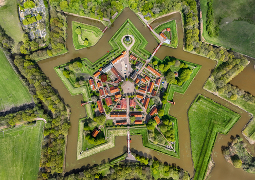 Aerial view of the historic star shaped Fort Bourtange with its intricate moats and green embankments surrounded by lush trees Bourtange Groningen Netherlands. Aerial view of the historic star shaped Fort Bourtange with its intricate moats and green embankments surrounded by lush trees Bourtange Groningen Netherlands.