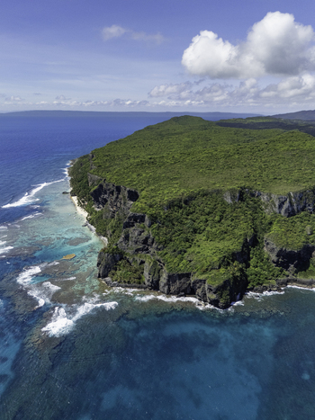 Aerial view of Playa Fronton featuring dramatic cliffs covered in lush tropical vegetation turquoise waters and coral reefs along the coastline in Samana Samana Dominican Republic. Aerial view of Playa Fronton featuring dramatic cliffs covered in lush tropical vegetation turquoise waters and coral reefs along the coastline in Samana Samana Dominican Republic.