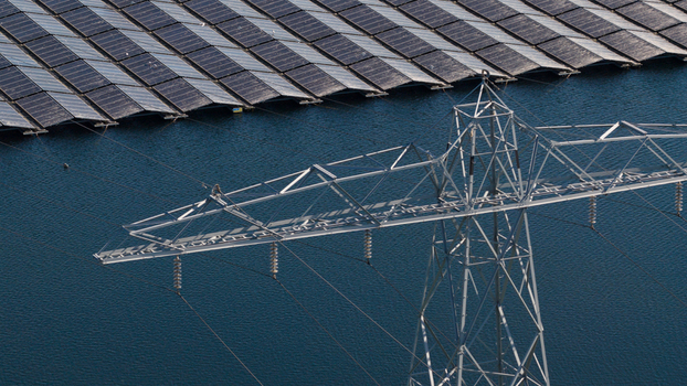 Aerial view of floating solar panels on a lake with a high voltage electricity pylon in the foreground Zwolle Overijssel Netherlands. Aerial view of floating solar panels on a lake with a high voltage electricity pylon in the foreground Zwolle Overijssel Netherlands.