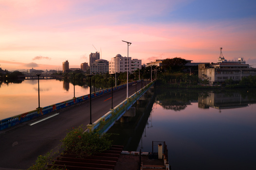 Aerial view of the bridge over the Iloilo River reflects the pastel hues of dawn casting a tranquil glow over the cityscape Iloilo City Western Visayas Philippines. Aerial view of the bridge over the Iloilo River reflects the pastel hues of dawn casting a tranquil glow over the cityscape Iloilo City Western Visayas Philippines.