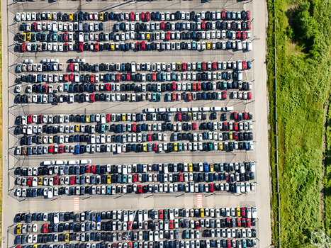 Aerial view of rows of colorful cars parked in a large logistics lot next to green fields in Rivalta di Torino Piedmont Italy. Aerial view of rows of colorful cars parked in a large logistics lot next to green fields in Rivalta di Torino Piedmont Italy.