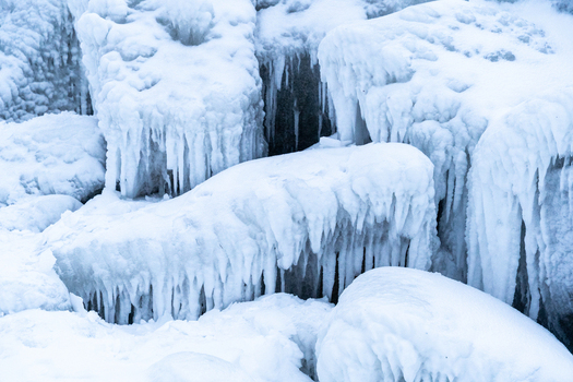View of the ice covered rocks and structures near the Molenfeuer Sassnitz featuring thick icicles and frozen sea spray along the coast in Sassnitz Mecklenburg Vorpommern Germany.