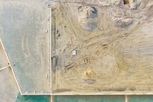 Aerial view of a residential development construction site with sandy ground tire tracks and construction materials in Perth Western Australia Australia. Aerial view of a residential development construction site with sandy ground tire tracks and construction materials in Perth Western Australia Australia.