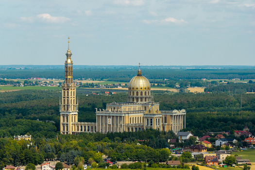 Aerial view of the Basilica of Our Lady of Lichen with its golden dome and tall tower surrounded by lush green forests and rural landscape in Lichen Stary Wielkopolskie Poland. Aerial view of the Basilica of Our Lady of Lichen with its golden dome and tall tower surrounded by lush green forests and rural landscape in Lichen Stary Wielkopolskie Poland.