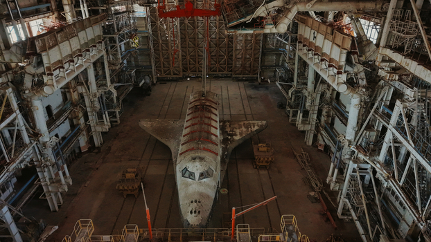Aerial view of the abandoned Buran space shuttle inside a hangar at Baikonur Cosmodrome featuring weathered tiles and steel scaffolding in Karmakshy District Kyzylorda Region Kazakhstan.