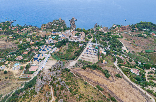 Aerial view of Riserva Naturale Orientata dello Zingaro with rugged coastal cliffs Mediterranean vegetation and historic stone structures near the sea in San Vito Lo Capo Sicilia Italy. Aerial view of Riserva Naturale Orientata dello Zingaro with rugged coastal cliffs Mediterranean vegetation and historic stone structures near the sea in San Vito Lo Capo Sicilia Italy.