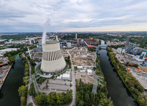 Aerial view of the Heizkraftwerk Reuter West power plant featuring its cooling tower industrial infrastructure and river landscape in Berlin Berlin Germany.