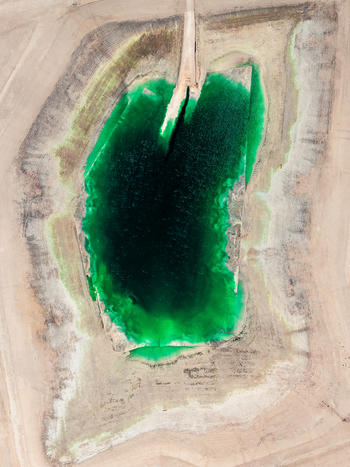 Aerial view of a vibrant green industrial pond with phosphor deposits surrounded by arid textured terrain in Andalusia Spain. Aerial view of a vibrant green industrial pond with phosphor deposits surrounded by arid textured terrain in Andalusia Spain.