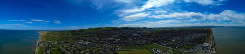 Aerial view of the coastal town nestled between the Irish Sea and rolling green hills under a vast azure sky Prestatyn Wales United Kingdom. Aerial view of the coastal town nestled between the Irish Sea and rolling green hills under a vast azure sky Prestatyn Wales United Kingdom.