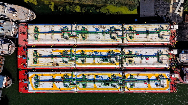 Aerial view of industrial barges docked at the Smederevo shipyard featuring colorful decks with piping systems on the Danube river in Smederevo Podunavlje District Serbia. Aerial view of industrial barges docked at the Smederevo shipyard featuring colorful decks with piping systems on the Danube river in Smederevo Podunavlje District Serbia.