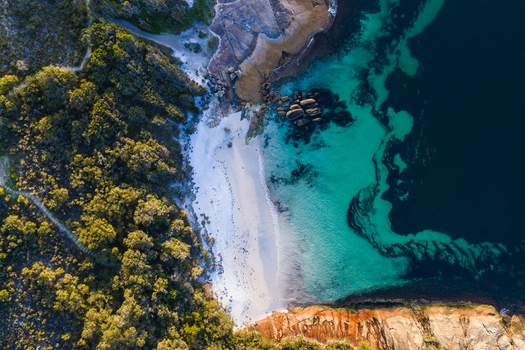 Aerial view of Camp Quaranup featuring a pristine white sand beach turquoise coastal waters rocky formations and dense native vegetation on the Vancouver Peninsula Western Australia Australia. Aerial view of Camp Quaranup featuring a pristine white sand beach turquoise coastal waters rocky formations and dense native vegetation on the Vancouver Peninsula Western Australia Australia.