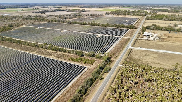 Aerial view of a vast solar panel farm stretching across the landscape contrasting against the rural backdrop Elkton Florida United States. Aerial view of a vast solar panel farm stretching across the landscape contrasting against the rural backdrop Elkton Florida United States.
