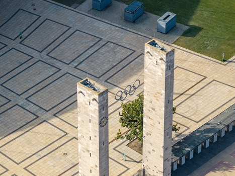 Berlin Germany 26 September 2026 Aerial view of Olympiastadion Berlin featuring the iconic Olympic rings suspended between two stone towers above a paved plaza.