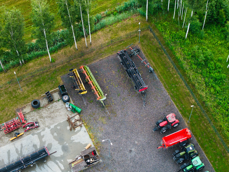 Aerial view of agricultural machinery including tractors and harvesters parked in a gravel yard at a modern sales and service center in Brankas Jelgava Municipality Latvia. Aerial view of agricultural machinery including tractors and harvesters parked in a gravel yard at a modern sales and service center in Brankas Jelgava Municipality Latvia.