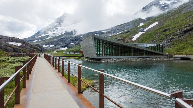 Andalsnes Norway 23 June 2024 View of Trollstigen visitor center with its modern architecture a pedestrian walkway over a clear pond and misty mountains in the background. Andalsnes Norway 23 June 2024 View of Trollstigen visitor center with its modern architecture a pedestrian walkway over a clear pond and misty mountains in the background.