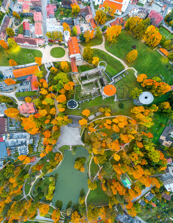 Aerial view of Cesis Castle ruins surrounded by autumn trees green parkland and a pond in Cesis Cesis Municipality Latvia. Aerial view of Cesis Castle ruins surrounded by autumn trees green parkland and a pond in Cesis Cesis Municipality Latvia.