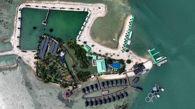 Aerial view of Pulau Lima Resort featuring overwater bungalows a swimming pool sandy beaches and surrounding clear turquoise waters in Kasemen Banten Indonesia. Aerial view of Pulau Lima Resort featuring overwater bungalows a swimming pool sandy beaches and surrounding clear turquoise waters in Kasemen Banten Indonesia.