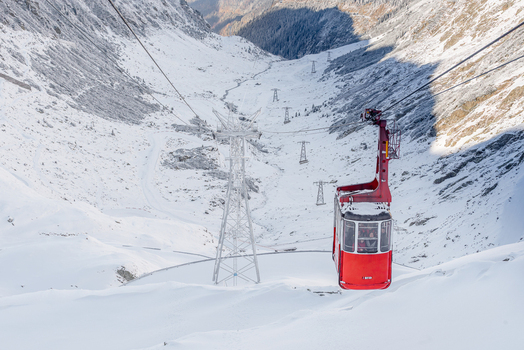 View of the red cable car ascending over the snow covered Transfagarasan mountain pass in the Carpathian Mountains Curtea de Arges Arges County Romania. View of the red cable car ascending over the snow covered Transfagarasan mountain pass in the Carpathian Mountains Curtea de Arges Arges County Romania.