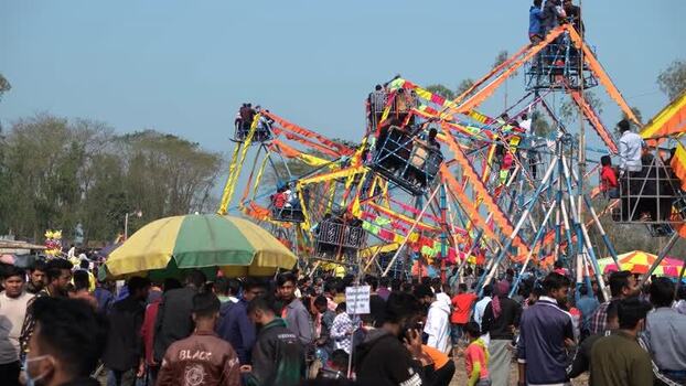 View of a crowded carnival with a traditional Ferris wheel Bangladesh. View of a crowded carnival with a traditional Ferris wheel Bangladesh.