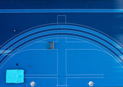 Aerial view of a vibrant blue athletics track with a high jump mat and lane markings in Santo Domingo Distrito Nacional Dominican Republic.