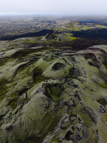 Aerial view of moss covered volcanic craters and rugged lava fields meet under a misty sky creating a landscape of stark beauty and geological wonder Lakagigar Iceland. Aerial view of moss covered volcanic craters and rugged lava fields meet under a misty sky creating a landscape of stark beauty and geological wonder Lakagigar Iceland.